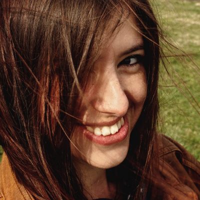 stylish beautiful brunette girl walking and smilling outdoors in spring portrait